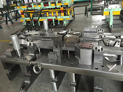 What are the classifications of continuous stamping dies?